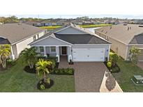 Charming single-story home with a well-manicured lawn, brick driveway, and attached two-car garage at 14238 59Th E Cir, Bradenton, FL 34211