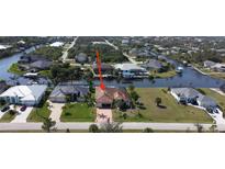 Beautiful waterfront property featuring lush landscaping and private boat dock at 15484 Alsask Cir, Port Charlotte, FL 33981