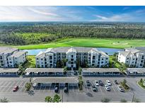 An aerial view of a condo community overlooking a golf course and water feature with covered parking and beautiful landscaping at 18008 Gawthrop Dr # 308, Bradenton, FL 34211