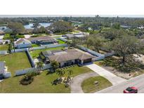 An aerial view of a single-Gathering home featuring a screened-in pool, lush landscaping, and water views at 2211 51St W St, Bradenton, FL 34209