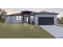 Contemporary home featuring a gray and white exterior, well-manicured lawn, and a sleek black garage door at 302 Liden St, Port Charlotte, FL 33953