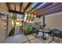 Inviting patio featuring a pergola, seating area, and lush landscaping for outdoor relaxation at 3183 Windrush Bourne # 42, Sarasota, FL 34235