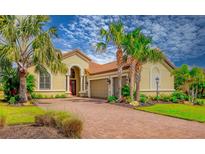 Charming home with a brick driveway, well-manicured lawn, lush tropical plants and a two-car garage at 4719 Cabreo Ct, Bradenton, FL 34211