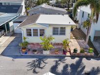 Charming yellow home with a new roof, complemented by lush landscaping and a brick patio at 7 High St, Bradenton, FL 34208