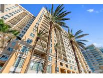 Upscale condo building exterior boasts multiple balconies and inviting tropical palm trees at 750 N Tamiami Trl # 407, Sarasota, FL 34236