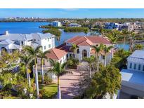 Aerial view of a luxury home with a tile roof, surrounded by water and lush landscaping at 1137 N Lake Shore Dr, Sarasota, FL 34231