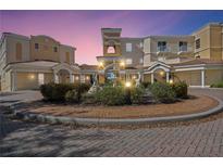 Stunning building exterior featuring a landscaped roundabout, tile roof, and neutral color palette at 14021 Bellagio Way # 309, Osprey, FL 34229
