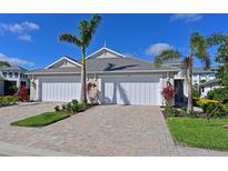 Charming villa with a two-car garage, brick paved driveway and tropical landscaping at 209 Okeeffe Cir, Bradenton, FL 34212