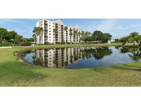 Scenic view of a resort-style building reflected in a pond, surrounded by lush greenery and palm trees at 2320 Terra Ceia Bay Blvd # 808, Palmetto, FL 34221