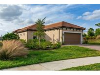 Charming single-story home featuring a well-maintained lawn and a clay tile roof on a sunny day at 3008 Tolmino Ct, Lakewood Ranch, FL 34211