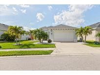 Charming single-story home with well-manicured lawn, palm trees, and a two-car garage at 3711 Manorwood Loop, Parrish, FL 34219