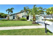 Charming home with lush lawn, lovely palms and stone accents creating inviting curb appeal at 4712 Glenbrooke Dr, Sarasota, FL 34243