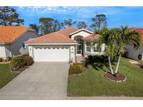 Charming single Gathering home featuring a two-car garage, lush landscaping and a beautiful lawn at 4811 Summertree Rd, Venice, FL 34293