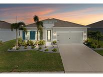 Charming single-story home featuring a well-maintained lawn, fresh landscaping, and a two-car garage at 6306 115Th E Ave, Parrish, FL 34219
