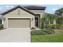 Charming home exterior featuring a stone facade, two-car garage, and well-maintained landscaping at 1604 Still River Dr, Venice, FL 34293
