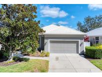 Charming single-story home with a gray exterior, concrete driveway, two-car garage and well maintained landscaping at 5003 88Th E St, Bradenton, FL 34211
