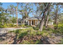 Charming one-story home with a welcoming entrance and beautifully landscaped front yard surrounded by mature trees at 5954 River Forest Cir, Bradenton, FL 34203