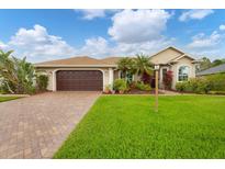 Charming single-story home featuring a two-car garage, lush landscaping, and a well-maintained lawn at 6211 90Th Avenue E Cir, Parrish, FL 34219