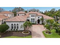 Stunning exterior showcasing a tile roof, lush landscaping, and a beautiful brick driveway at 7210 Desert Ridge Gln, Lakewood Ranch, FL 34202