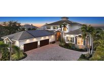 Elegant two-story home showcasing stone accents, lush landscaping, and a paved driveway leading to a two-car garage at 7706 Desoto Memorial Hwy, Bradenton, FL 34209