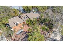 Stunning aerial view of a custom home with lush landscaping and brick circular driveway at 813 Plymouth St, Sarasota, FL 34242