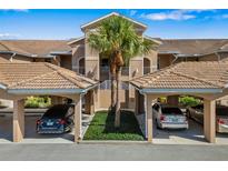 Inviting condo with covered parking, lush landscaping, and tile roof, offering comfort and convenience at 923 Fairwaycove Ln # 103, Bradenton, FL 34212