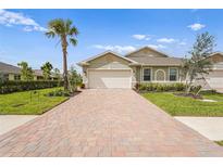 Charming single-story home featuring a brick driveway, palm tree, and manicured lawn at 1524 Remington Trace Dr, Port Charlotte, FL 33953