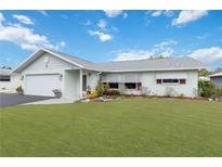 Well-maintained home with a lush green lawn, complemented by crisp, white trim and an attached garage at 1582 Overbrook Rd, Englewood, FL 34223