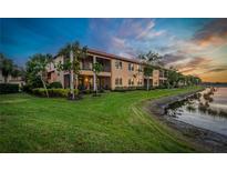 A well-maintained two story condo, featuring a lakeside view and lush green lawn at 23085 Banbury Way # 103, Venice, FL 34293