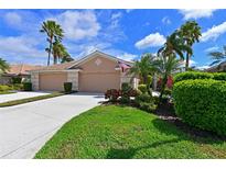Charming home with a well-manicured lawn, lush landscaping, and a welcoming double garage at 379 Fairway Isles Ln, Bradenton, FL 34212