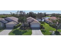 Charming single-story home with well-manicured lawn, lush landscaping, and a two-car garage at 5242 Highbury Cir, Sarasota, FL 34238