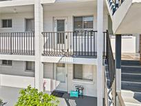 Condo building exterior featuring second story unit entrance with gray railings and gray stairway at 5907 Garden Ln # H26, Bradenton, FL 34207