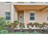 Inviting condo entrance featuring a decorative door and colorful landscaping at 803 Fairwaycove Ln # 106, Bradenton, FL 34212