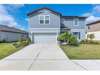 Charming two-story home featuring a manicured lawn and an attached two-car garage at 11531 Moonsail Dr, Parrish, FL 34219
