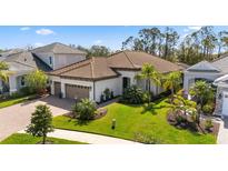 Stunning exterior with lush landscaping, paver driveway, and beautiful tile roof at 11981 Hunters Creek Rd, Venice, FL 34293