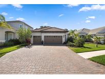 Beautiful home exterior with a paved driveway, a three car garage and manicured landscaping at 11981 Hunters Creek Rd, Venice, FL 34293