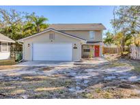 Inviting two-story home with a spacious driveway, a two-car garage, and a vibrant red front door at 2219 12Th W Ave, Bradenton, FL 34205