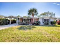 Charming single-story home featuring a well-manicured lawn and a convenient carport at 3042 Lockwood Ter, Sarasota, FL 34231