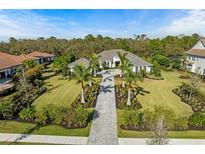 Stunning single-story home with lush landscaping, stone driveway, and a grand entrance at 8455 Lindrick Ln, Bradenton, FL 34202