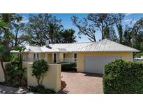 Charming single-story home with well-manicured landscaping and a brick driveway at 980 S Orange Ave, Sarasota, FL 34236