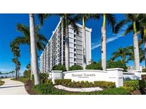Exterior shot of the Sunset Towers building, showcasing its modern design and lush landscaping at 11 Sunset Dr # 303, Sarasota, FL 34236
