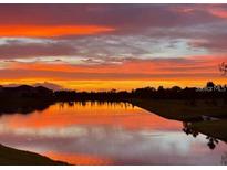 Beautiful sunset reflecting on a pond, painting the sky with vivid orange and purple hues at 12534 Nantahala Run Run, Parrish, FL 34219