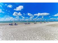 Scenic beach view featuring multiple beach chairs and umbrellas near the shoreline at 1465 Gulf Of Mexico Dr # 104, Longboat Key, FL 34228