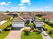 Stunning home with a tile roof, lush landscaping, and a three-car garage on a sunny day at 1805 7Th St E, Palmetto, FL 34221