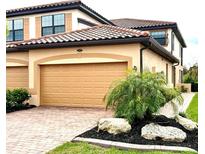 Charming home features brick driveway, two-car garage, well-maintained landscaping and a tile roof at 20080 Ragazza Cir # 102, Venice, FL 34293