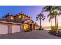 Beautiful waterfront home with brick driveway and three-car garage offers stunning sunset views at 202 Gaines Ave, Sarasota, FL 34243