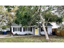 Charming single-story home with a bright yellow front door and beautifully landscaped yard at 3008 Hillview St, Sarasota, FL 34239