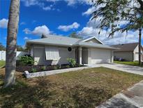 Beautifully landscaped single-story home with a two-car garage and shuttered windows at 3507 65Th Avenue E Cir, Sarasota, FL 34243