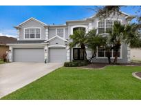 Charming two-story home with a three-car garage, well-manicured lawn, and mature palm trees at 4255 67Th Avenue E Cir, Sarasota, FL 34243