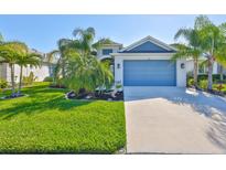 Charming single-story home with a well-maintained lawn, palm trees, and a blue garage door at 4516 Renwick Dr, Parrish, FL 34219